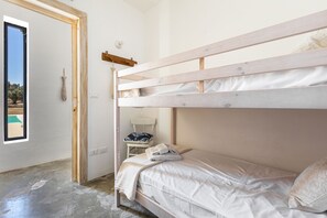 Habitación con literas y vista a una piscina a través de una puerta.