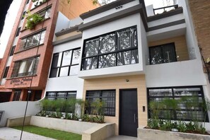 A modern multi-story building with large windows and balconies.