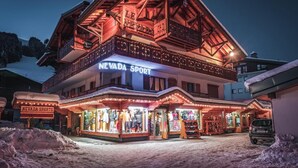 Een gebouw met twee verdiepingen, met een gevel in wintersportthema, inclusief een opvallend 'Nevada Sports' bord en een icoon van een skilift.
