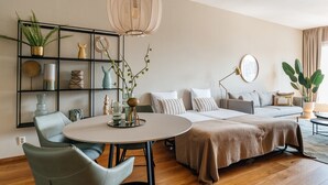 A modern bedroom with a bed, a round dining table, and a sofa. - Lovely Apartment in Den Haag (The Hague)