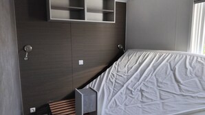 Un dormitorio moderno con cama, estanterías empotradas y mesita de noche.