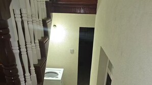 Eine Treppe mit Marmorstufen führt zu einer Zwischenebene mit einer Waschmaschine.