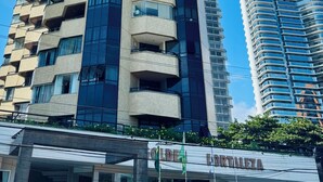 Un immeuble moderne et imposant, doté de nombreux balcons et d’une façade en verre.