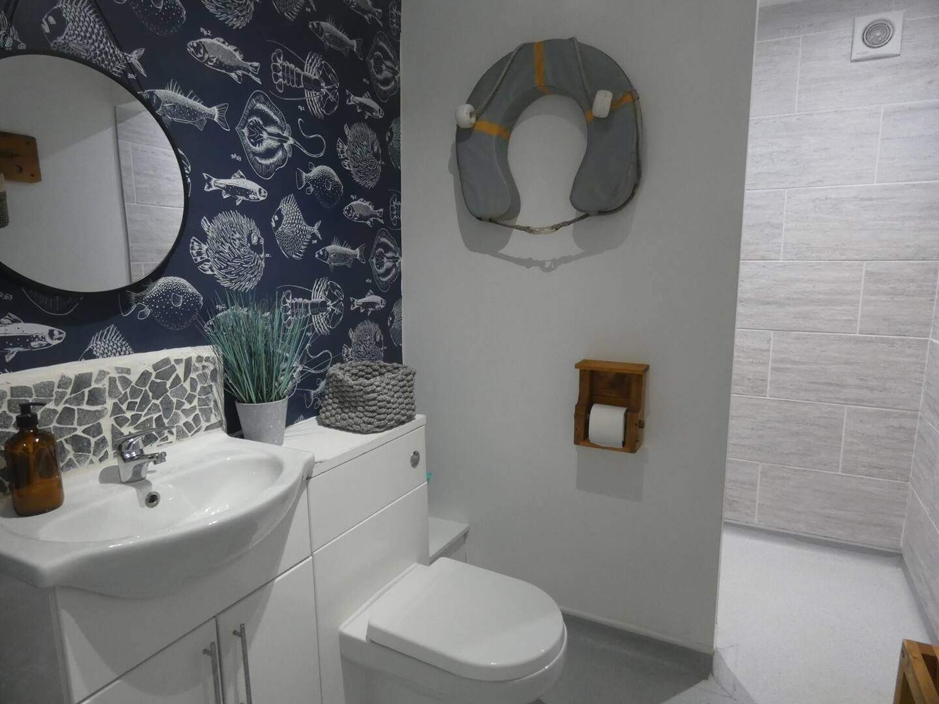 A bathroom with a sink, toilet, and a shower area.