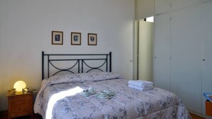 A bedroom with a bed, bedside table, and a wardrobe.