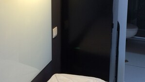 A narrow bathroom with a white sink, a dark wall, and a pendant light. - Naturiste Cap d'Agde Port Nature 650 (Agde)