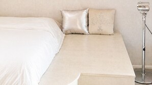 Ein Schlafzimmer mit einem Bett, Kissen und einer Wandleuchte.