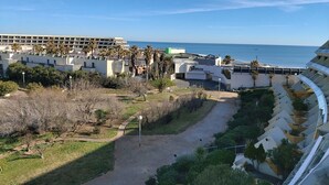 Ein Hotel mit modernem architektonischen Design, das eine geschwungene Bauweise und einen Weg zum Strand zeigt.