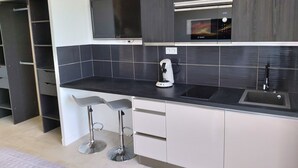 Eine moderne Küche mit schwarzem Arbeitsplatz, einer Bosch-Kaffeemaschine und einem eingebauten Backofen.