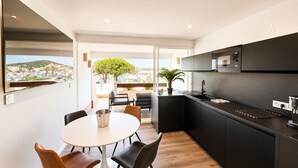 Una cocina moderna con comedor, vistas de la ciudad y un amplio ventanal.