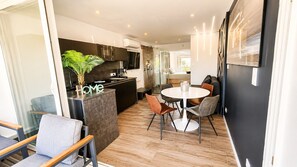 A modern kitchen with a dining area, a plant, and a 'HOME' sign.