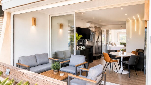 Un interior moderno con sofá, mesa de comedor y zona de cocina.