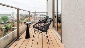 A balcony with a view of a cityscape, featuring a table and two chairs. - Spacious Apartment in Den Haag With View (The Hague)