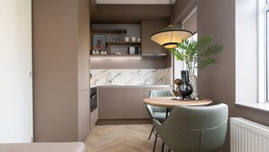 A compact kitchen with a dining area, featuring a marble backsplash, a pendant light, and a potted plant. - Cozy and Budget-friendly Studio Apartment (The Hague)