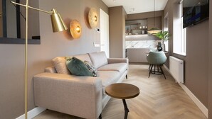 A modern living room with a sofa, a round coffee table, and a floor lamp. - Cozy and Budget-friendly Studio Apartment (The Hague)
