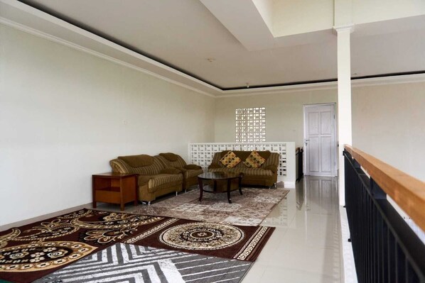 A living room with two sofas, a coffee table, and a patterned rug. - Palma Villa Bumi Dieng Indah (Wonosobo)