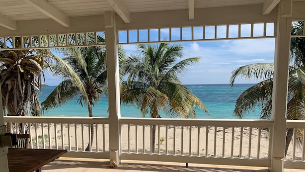 Un patio cubierto con vistas a la playa y al océano.