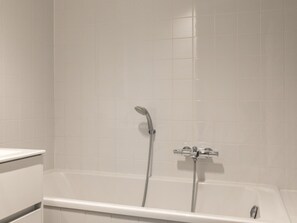 Une salle de bain avec une baignoire, une douche et des toilettes.