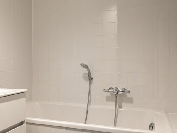 Une salle de bain avec une baignoire, une douche et des toilettes.