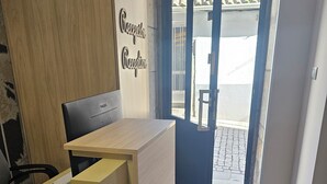 A reception desk with a wooden finish, a black Philips monitor, and a sign that reads "Reception". - HOSTAL MARIQUITO (Fisterra)