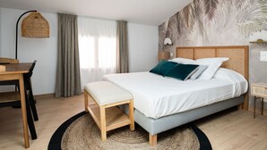 Een slaapkamer met een bed, een bureau en een stoel.