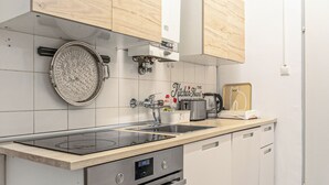 Cocina moderna con estufa integrada, pileta doble y armarios de madera.