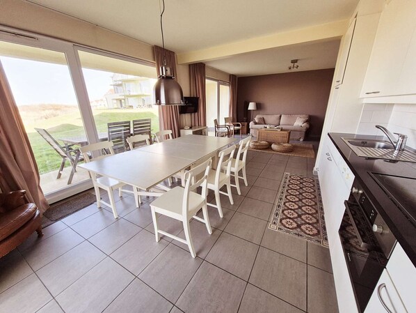Una cocina moderna con comedor, sofá y vistas al exterior.