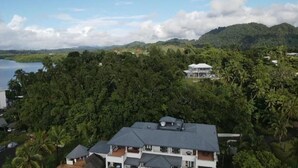 A coastal property with a large house surrounded by dense tropical vegetation and a view of the sea. - Suva Hideaway Villa (Suva)