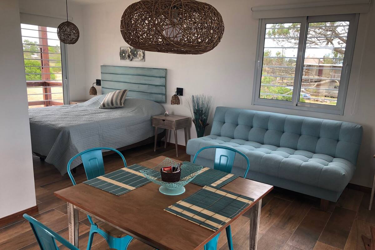 A bedroom with a bed, bedside table, and a window.
