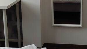 A hotel room with a bed, a stack of white towels, a bedside table, and a large mirror reflecting the bed and a painting on the wall. - Villa Anna, apartment no. 2 (Venezia)