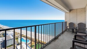 A balcony with a view of the beach and ocean. There are chairs and a table on the balcony. - Myrtle Beach Resort RT2111 (Myrtle Beach)