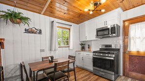 A kitchen with white cabinets, a stainless steel stove, and a microwave.