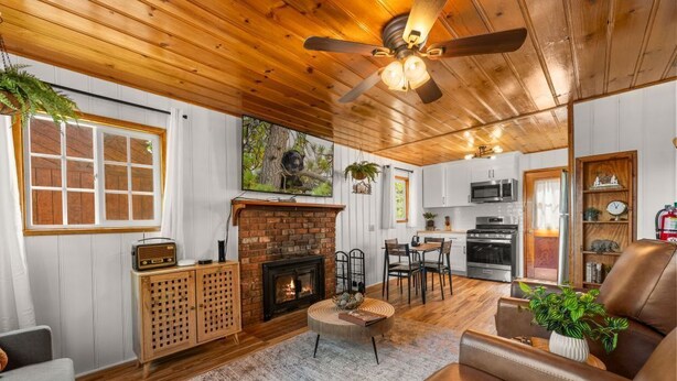 A cozy living room with a fireplace, a dining area, and a kitchen.