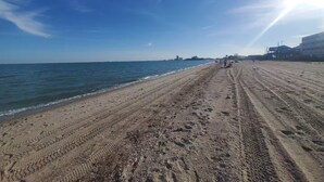 A beach with a clear sky, a sandy shore, and buildings in the background. - Private Bayview Condo (Corpus Christi)