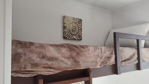 A bunk bed with a brown blanket and a framed picture on the wall. - Private Bayview Condo (Corpus Christi)