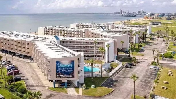 A hotel with multiple floors, a swimming pool, and a view of the ocean. - Private Bayview Condo (Corpus Christi)
