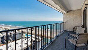 A balcony with a view of the beach and ocean. There are two chairs and a small table. - Myrtle Beach Resort RT1715 (Myrtle Beach)