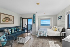 A room with a bed, a sofa, a coffee table, and a view of the ocean. - Myrtle Beach Resort RT1104 (Myrtle Beach)
