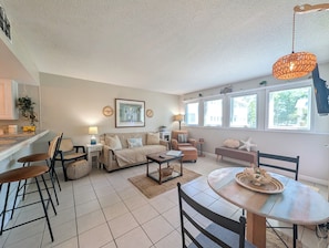 A modern living room with a sofa, chairs, a coffee table, and a dining table.