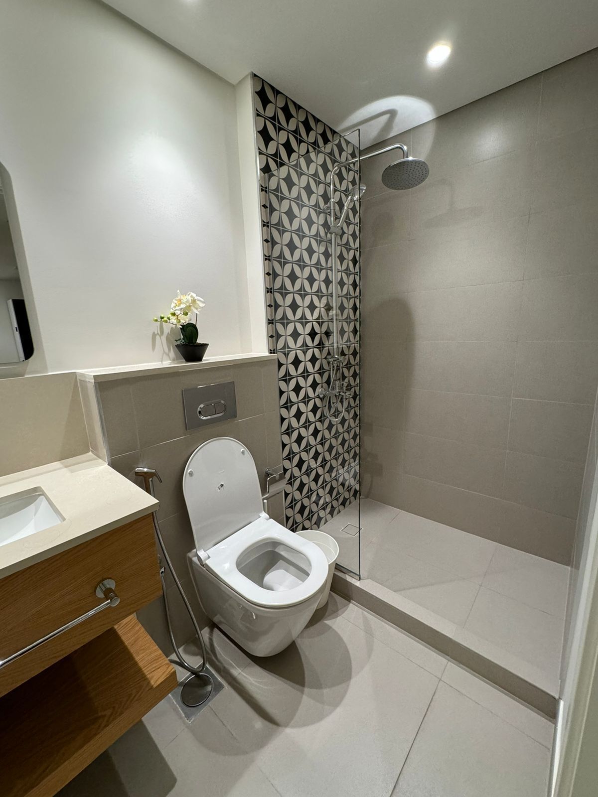 A modern bathroom with a toilet, sink, and shower.