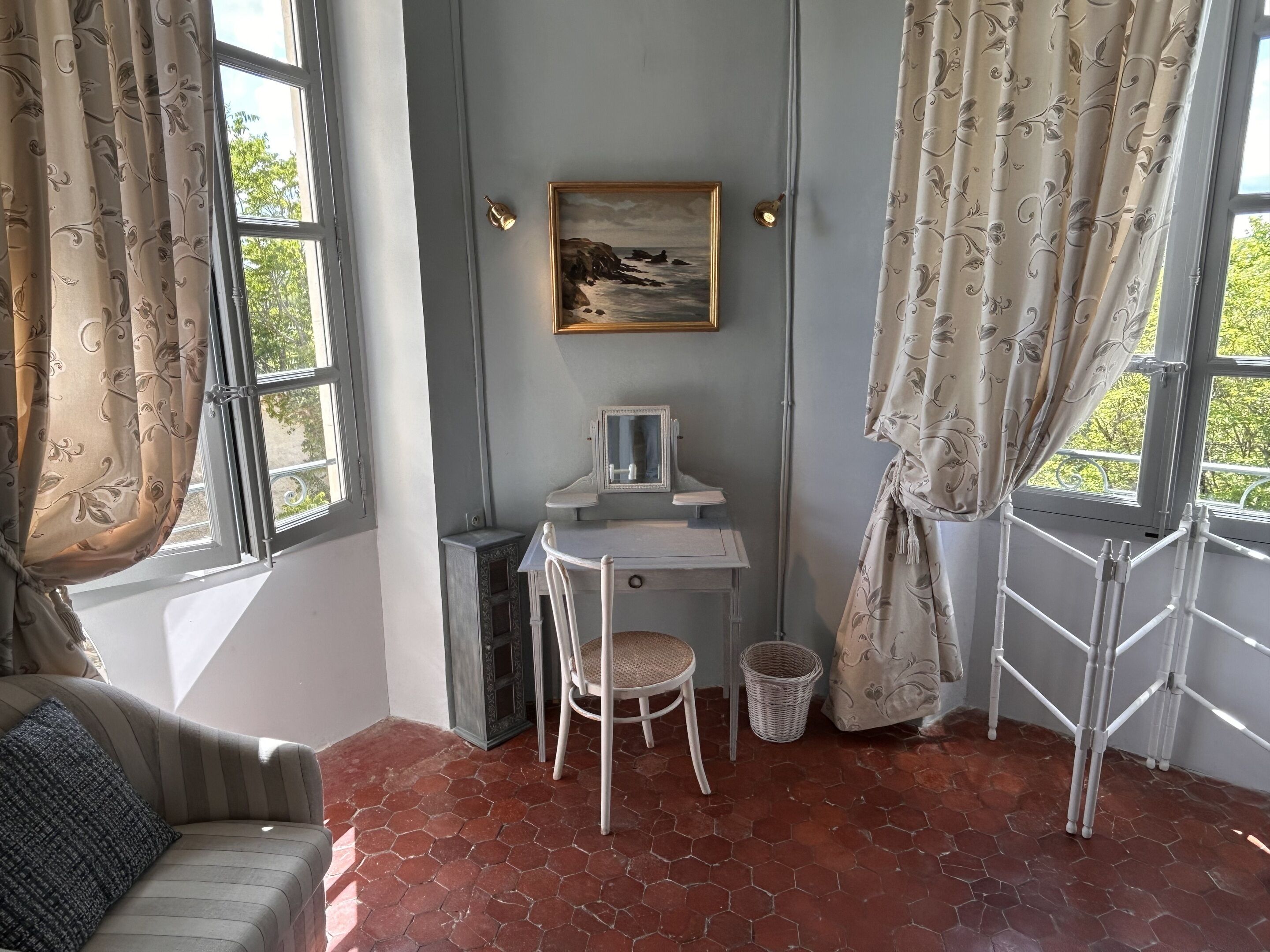 Una habitación con escritorio, silla y un cuadro en la pared.