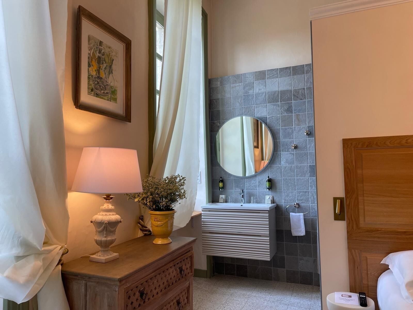 A bathroom with a sink, mirror, and a wooden cabinet.