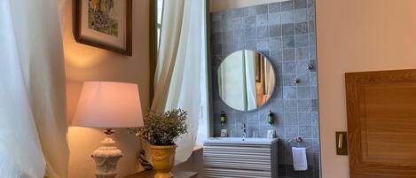 A bathroom with a sink, mirror, and a wooden cabinet.