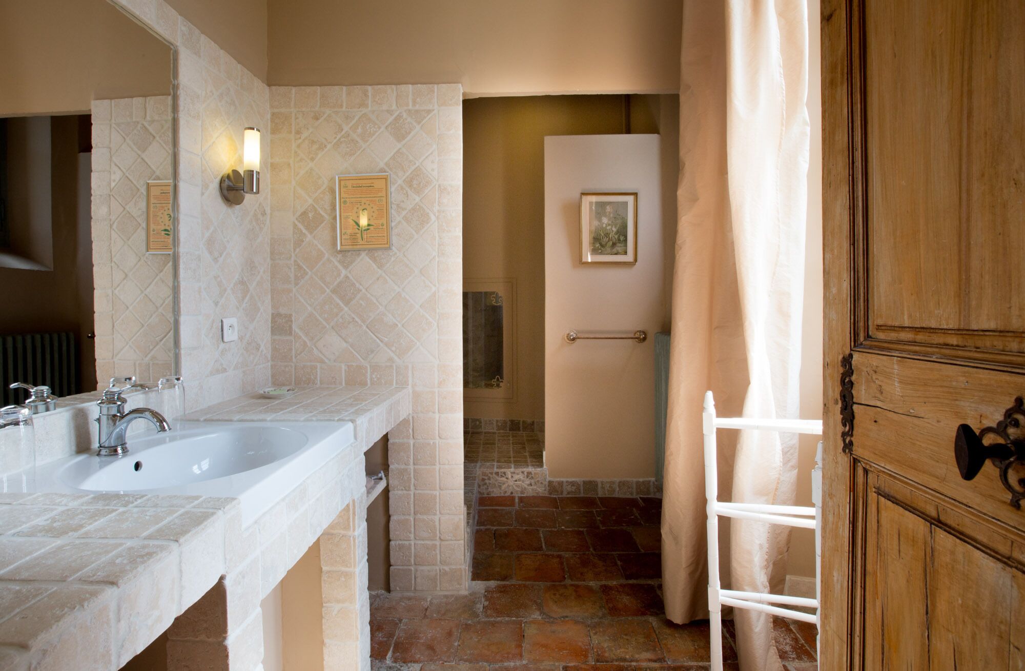 A bathroom with two sinks, a shower, and a wooden cabinet.