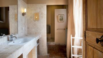 A bathroom with two sinks, a shower, and a wooden cabinet.