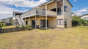 Ein zweistöckiges Haus mit Balkon, Satellitenschüssel und umzäunter Garten.