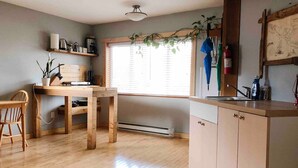Una cucina con mobili in legno, un tavolo da pranzo e una finestra con persiane.
