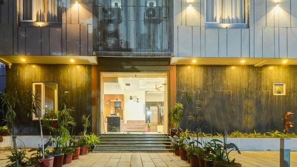 A modern hotel entrance with a welcoming staircase, potted plants, and a well-lit facade. - Comfort and Elegant Stays in Udaipur (Udaipur)