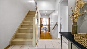 A staircase leading to a living area with a view of a dining table and chairs. - Charming Home with Parking & Private Fenced Yard (Mississauga)