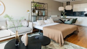 Ein modernes Wohnzimmer mit einer Couch, einem Couchtisch, einem Bücherregal und einem Essbereich.